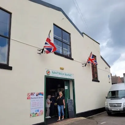 People entering Nayton Market building with Union Jack flags on the facade