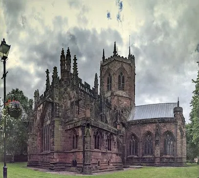 Historic Gothic church with ornate stone towers and arched windows under a cloudy sky